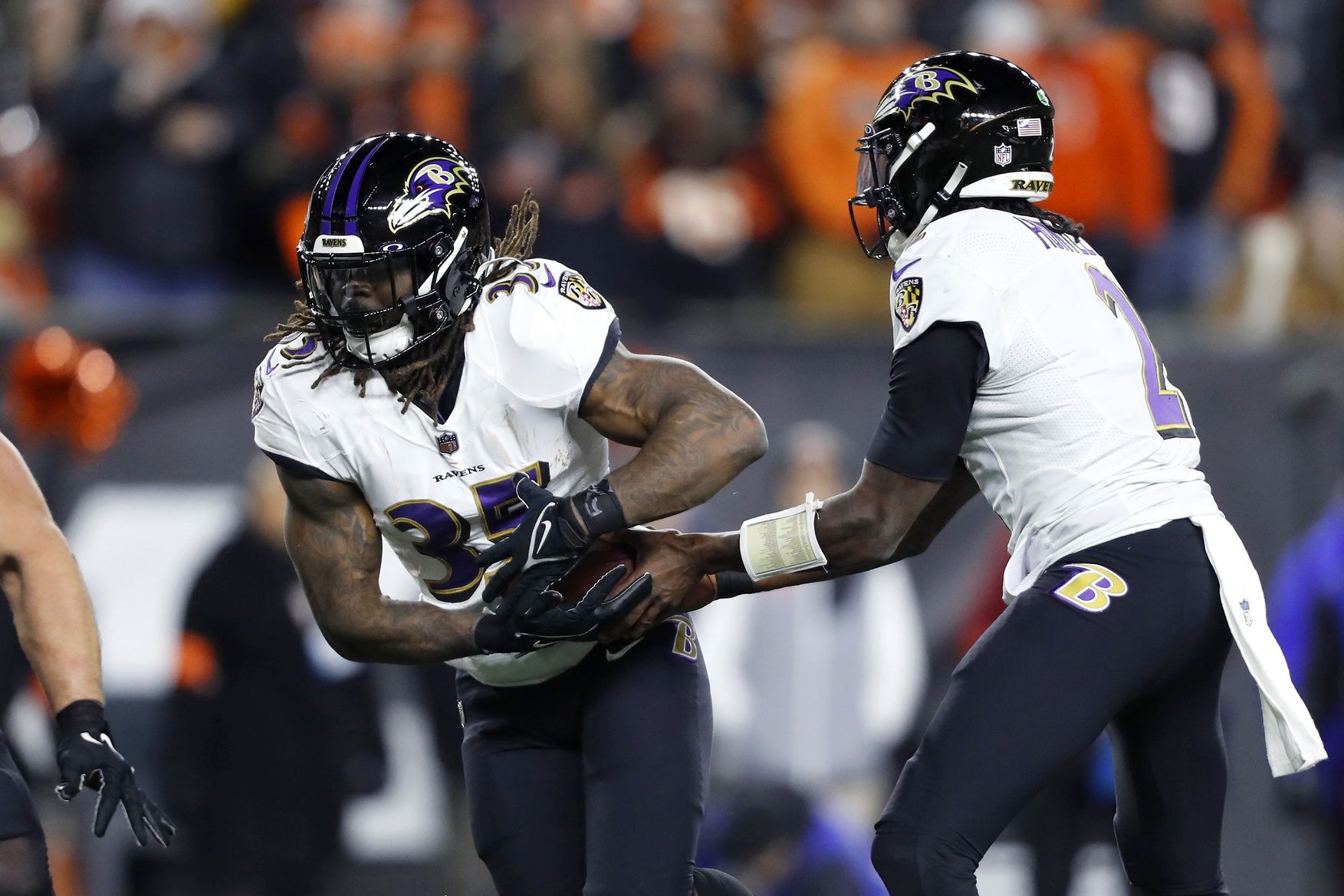 Baltimore Ravens QB Tyler Huntley (2) hands the ball off to RB Gus Edwards (35).
