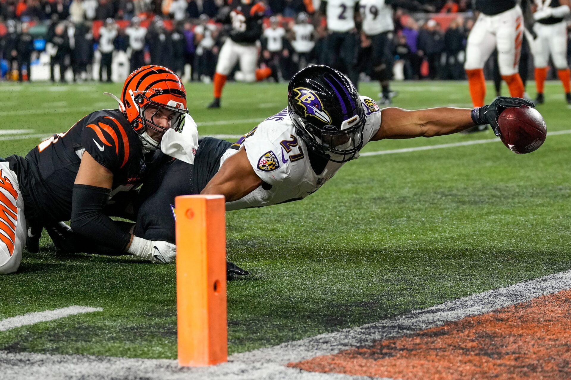 Baltimore Ravens running back J.K. Dobbins (27) breaks a tackle from Cincinnati Bengals linebacker Markus Bailey (51) stretches to break the plane for a touchdown in the second quarter during an NFL wild-card playoff football game between the Baltimore Ravens and the Cincinnati Bengals, Sunday, Jan. 15, 2023, at Paycor Stadium in Cincinnati.The Ravens led 10-9 at halftime.