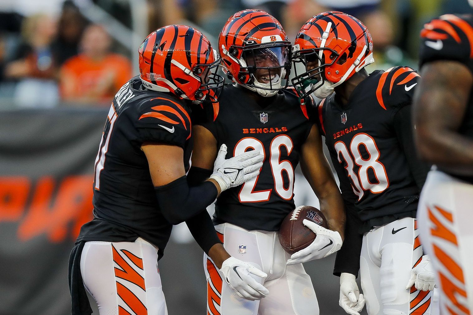 Tycen Anderson (26) reacts after a pick six with linebacker Markus Bailey (51) and cornerback DJ Ivey (38) in the first half against the Green Bay Packers at Paycor Stadium.