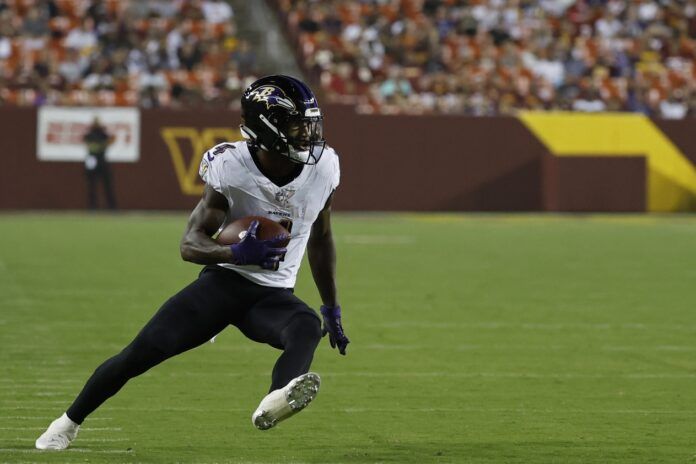 Zay Flowers (4) carries the ball en route to a touchdown against the Washington Commanders during the first quarter at FedExField.