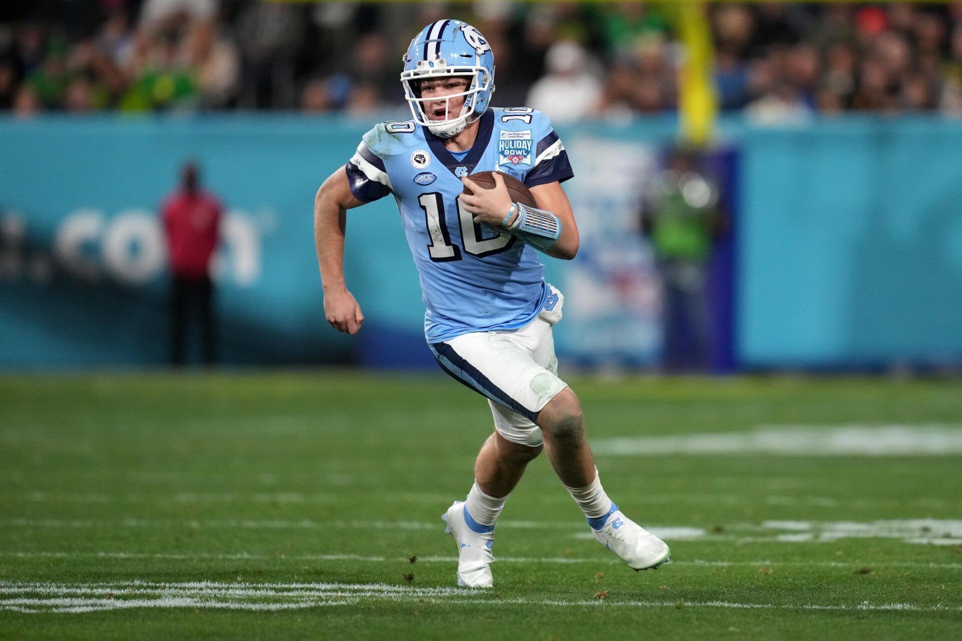 Drake Maye (10) carries the ball against the Oregon Ducks during the first half of the 2022 Holiday Bowl at Petco Park.