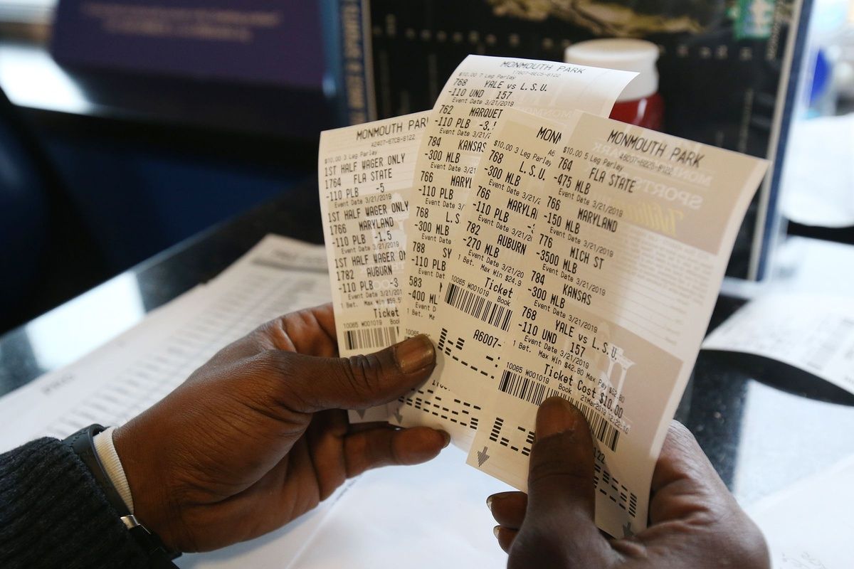 Charlie Rogers of Aberbeen, a former NFL player, displays his betting slips during March Madness, the NCAA menâ€™s college basketball tournament, at Monmouth Park's William Hill Race and Sports Bar.