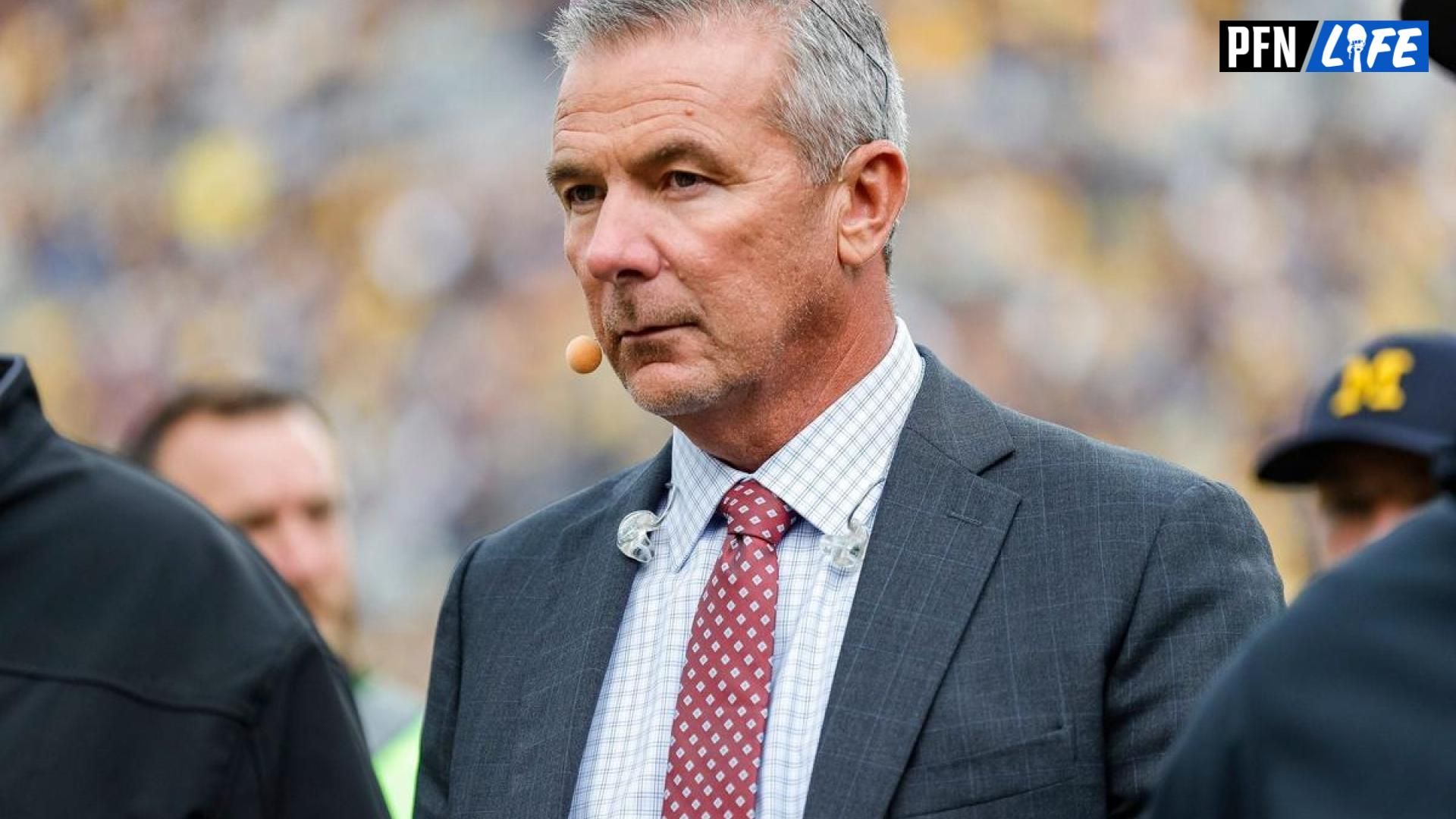 College football analyst Urban Meyer walks the sidelines before a game between Michigan and Maryland.