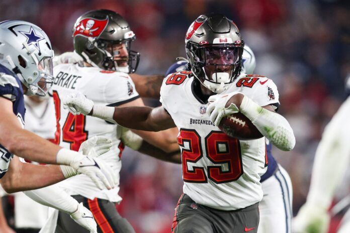 Rachaad White (29) runs with the ball against the Dallas Cowboys in the fourth quarter during a wild card game at Raymond James Stadium.