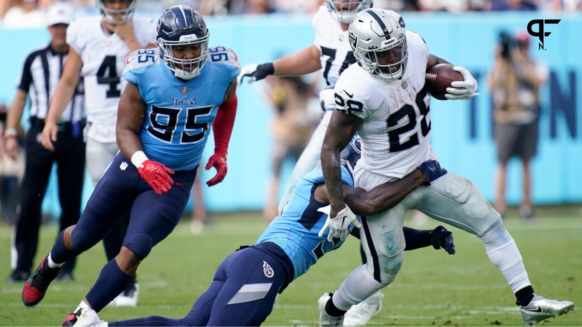 Las Vegas Raiders RB Josh Jacobs tries to break away from Tennessee Titans LB David Long Jr.