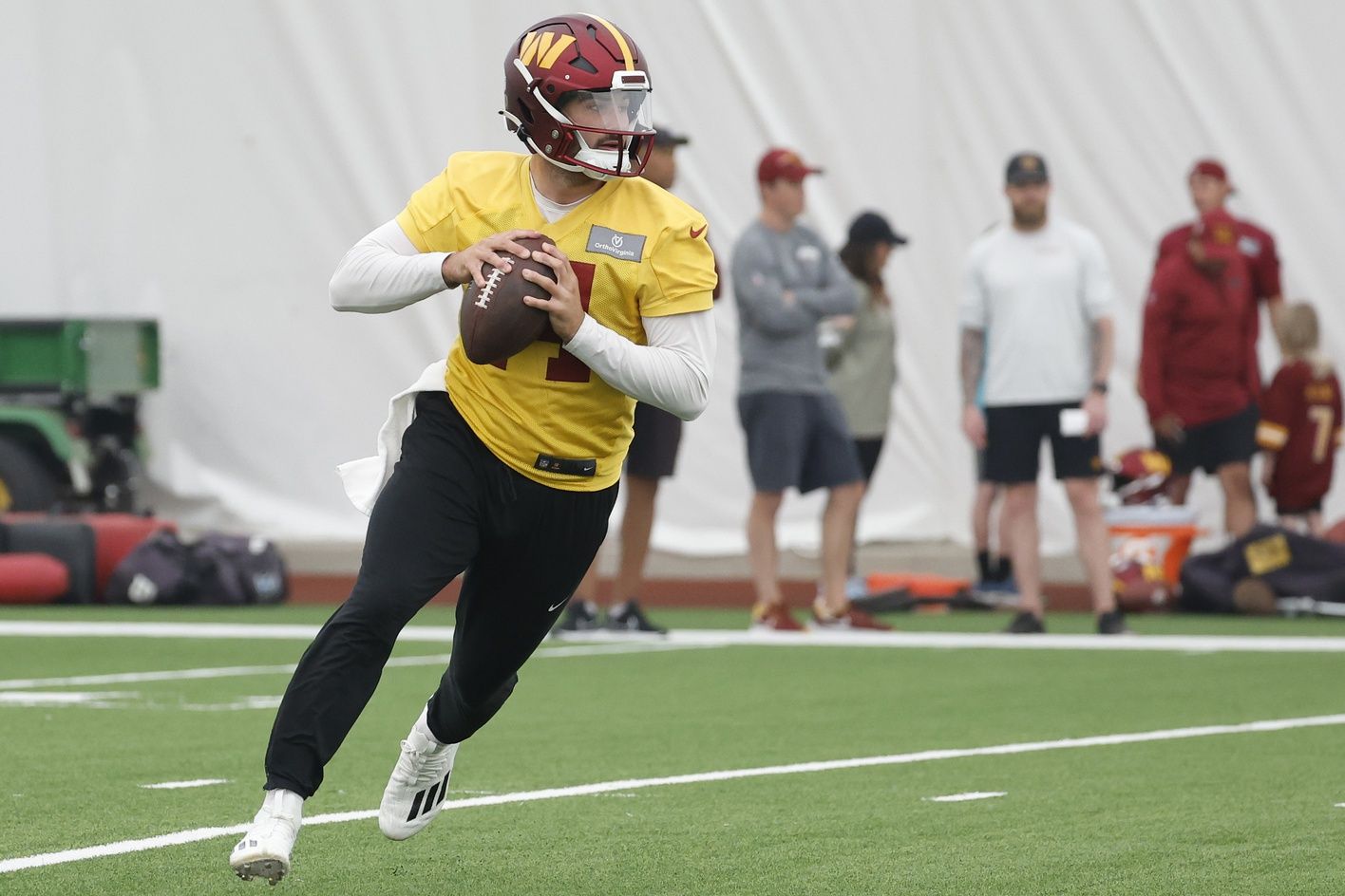 Washington Commanders QB Sam Howell (14) rolls out during a practice drill.