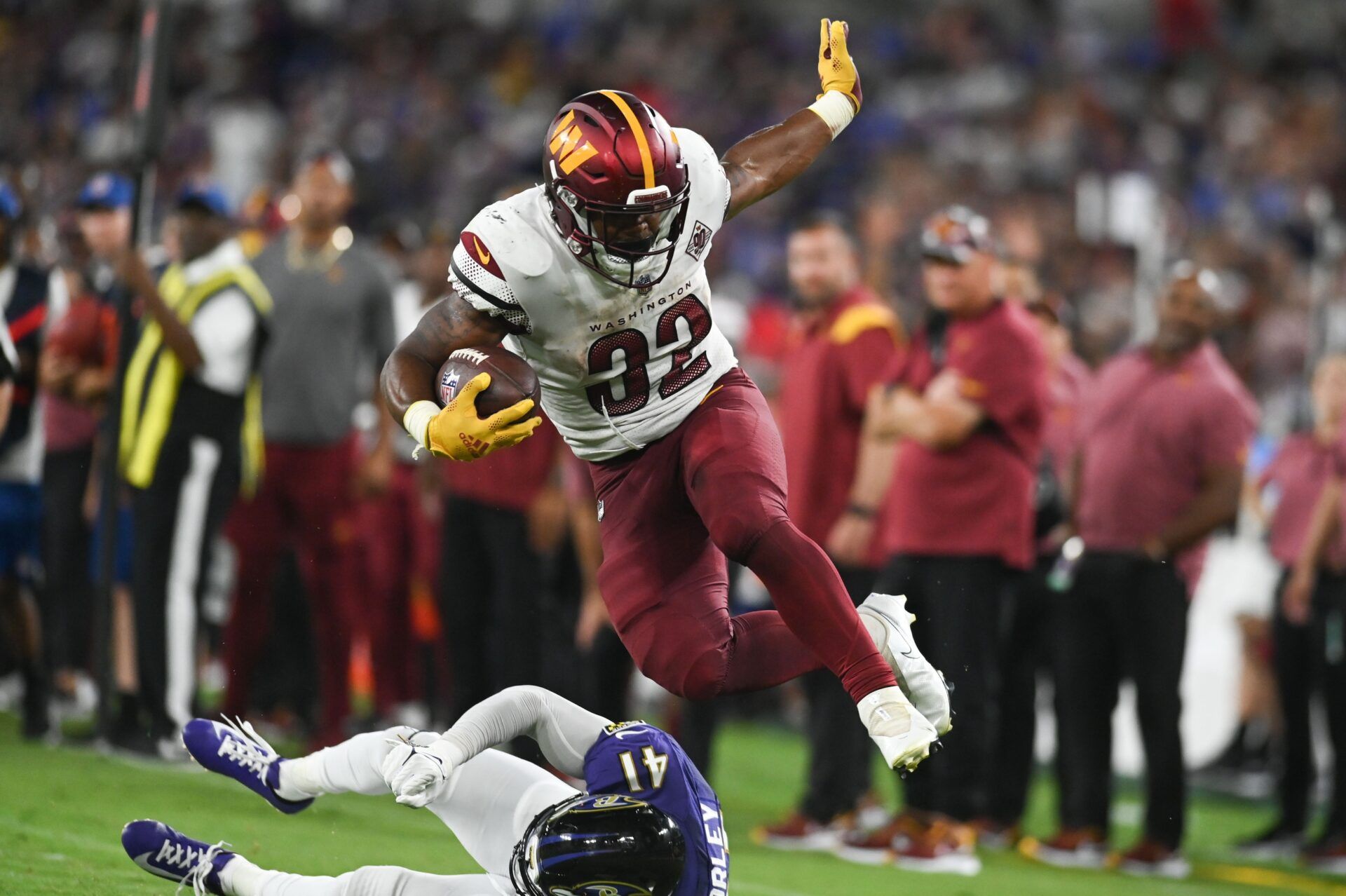 Washington Commanders RB Jaret Patterson (32) leaps over Baltimore Ravens CB Daryl Worley (41).