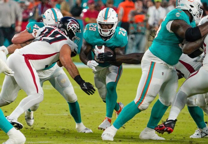 De'Von Achane (28) rushes during a preseason game at Hard Rock Stadium.