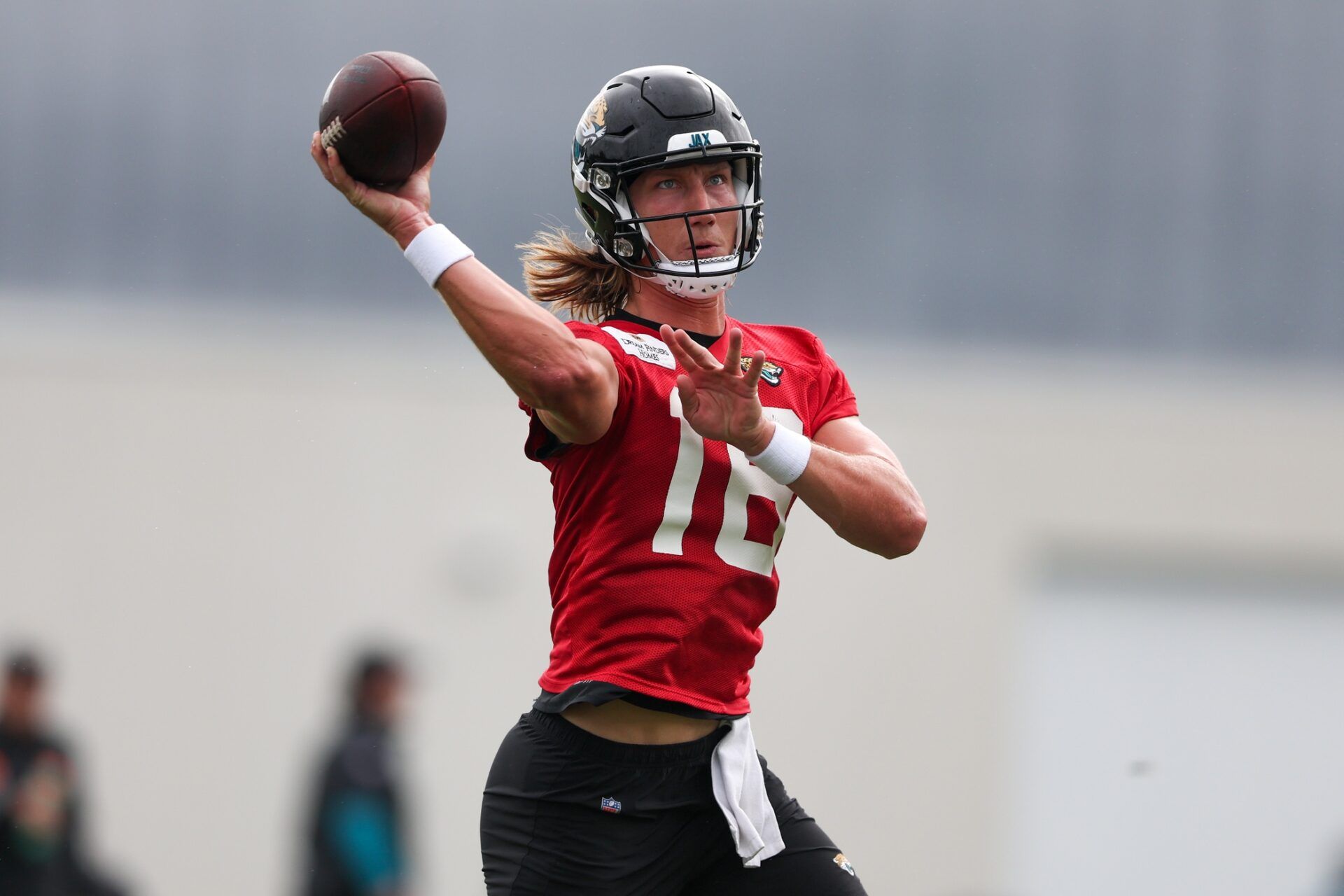 Jacksonville Jaguars QB Trevor Lawrence (16) throws passes during training camp.