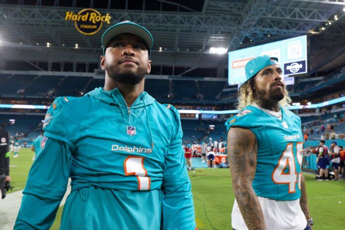 Miami Dolphins quarterback Tua Tagovailoa (1) and linebacker Duke Riley (45) walk off the field after a game against the Atlanta Falcons at Hard Rock Stadium.