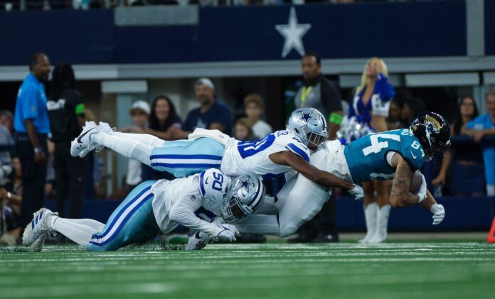 Jacksonville Jaguars wide receiver Elijah Cooks (84) makes a catch as Dallas Cowboys cornerback Josh Butler and Dallas Cowboys linebacker Devin Harper (50) defend during the second half at AT&T Stadium.