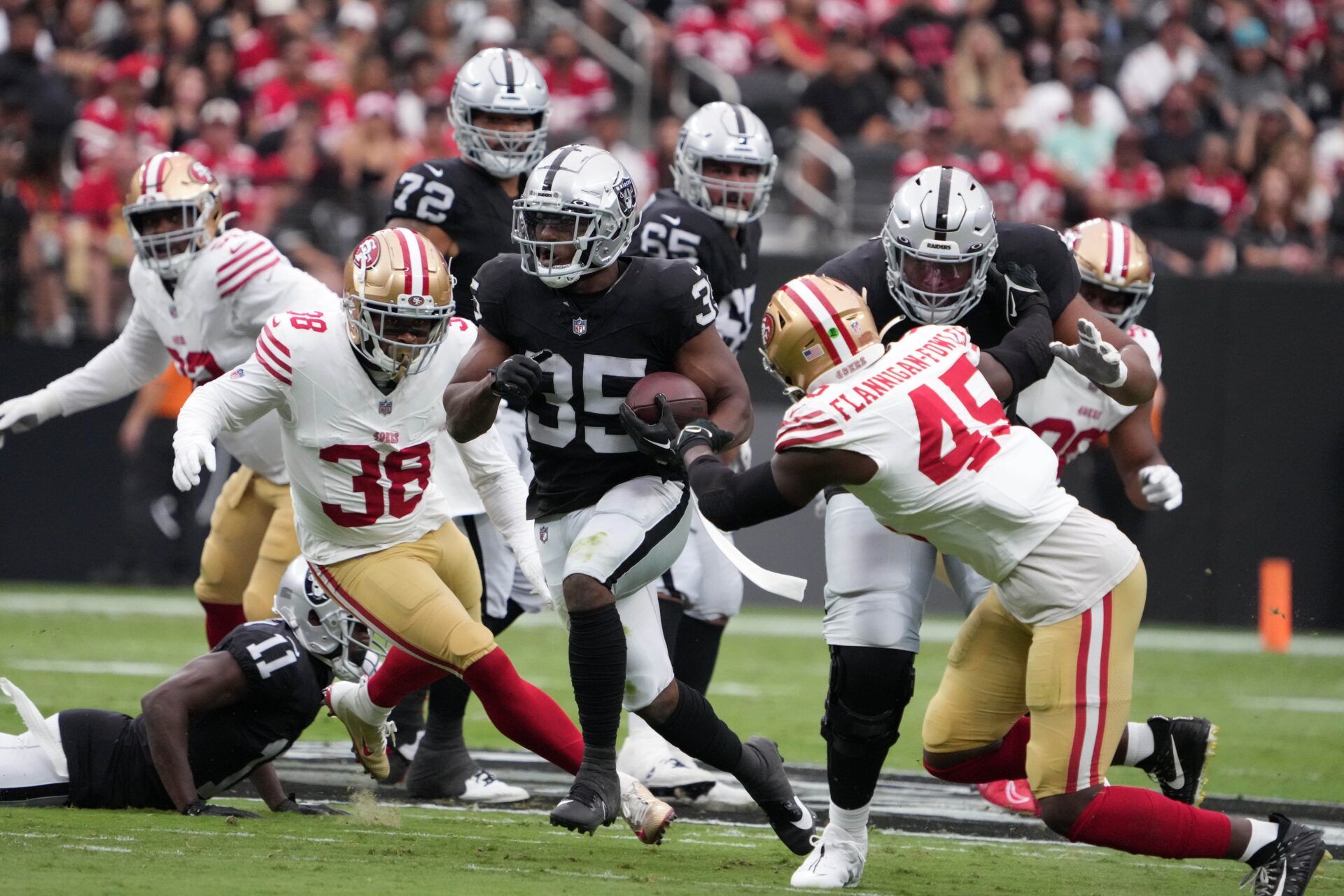 Zamir White (35) carries the ball against San Francisco 49ers safety Myles Hartsfield (38) and linebacker Demetrius Flannigan-Fowles (45) in the first half at Allegiant Stadium.