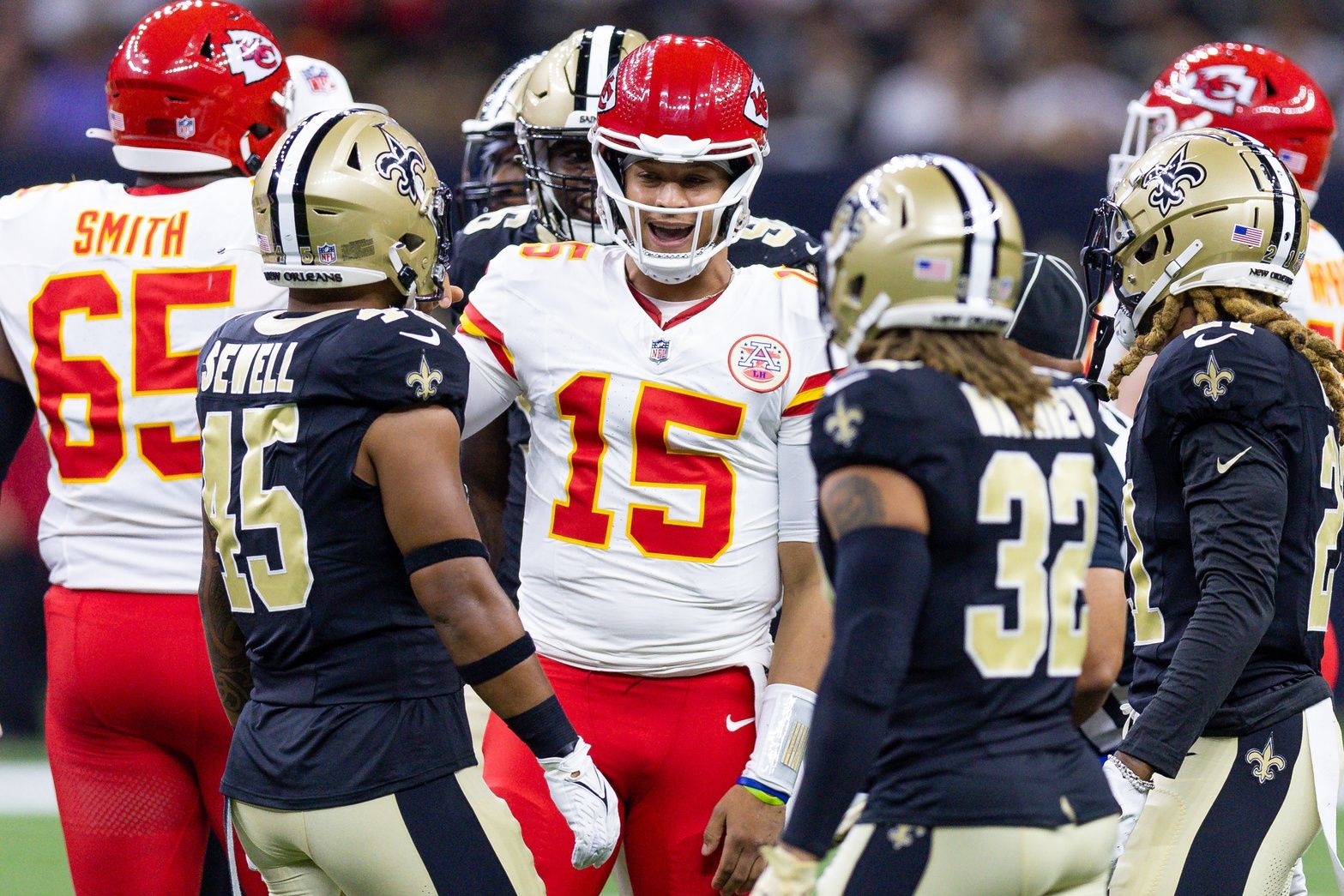 Kansas City Chiefs quarterback Patrick Mahomes (15) talks to New Orleans Saints linebacker Nephi Sewell (45) and safety Tyrann Mathieu (32) after being tackled during the first half at the Caesars Superdome.