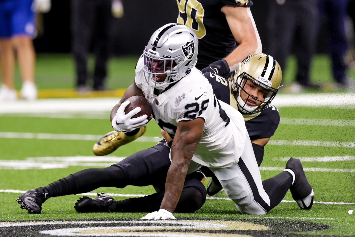 Las Vegas Raiders RB Josh Jacobs (28) gets tackled by New Orleans Saints safety Tyrann Mathieu (32).