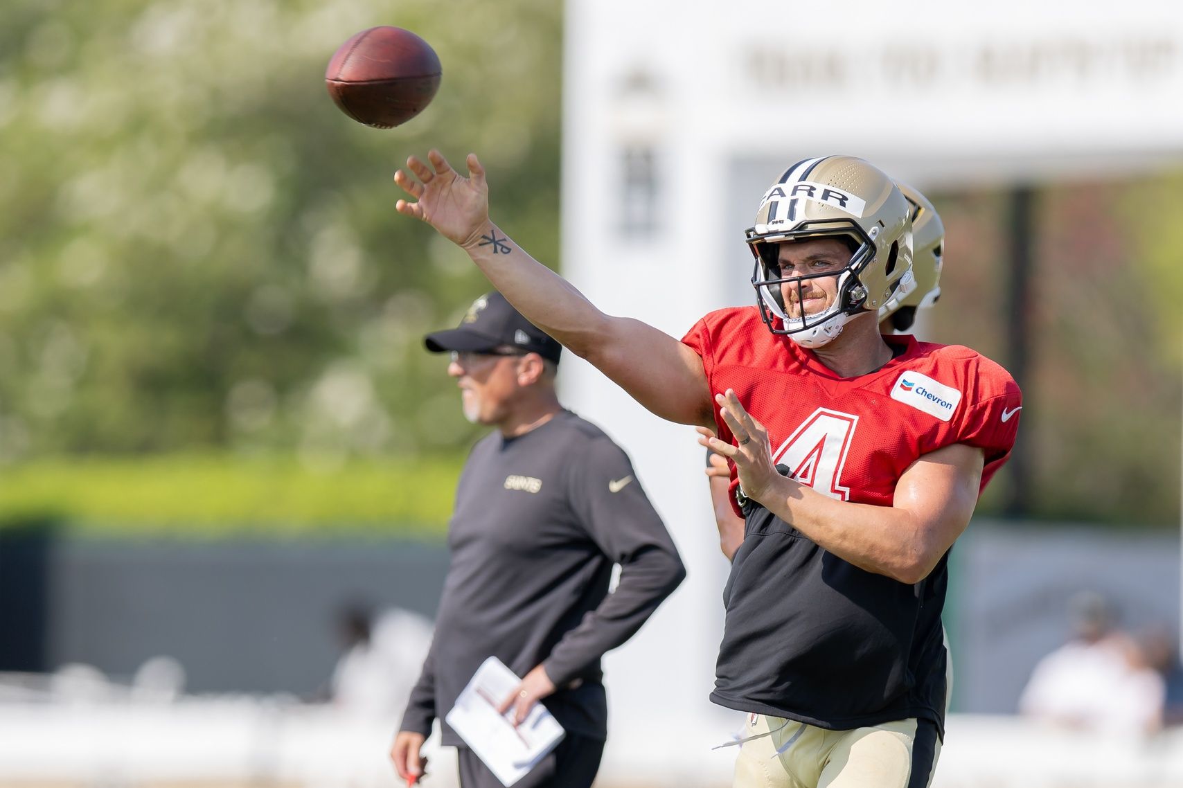 New Orleans Saints QB Derek Carr (4) throws passes during practice at training camp.