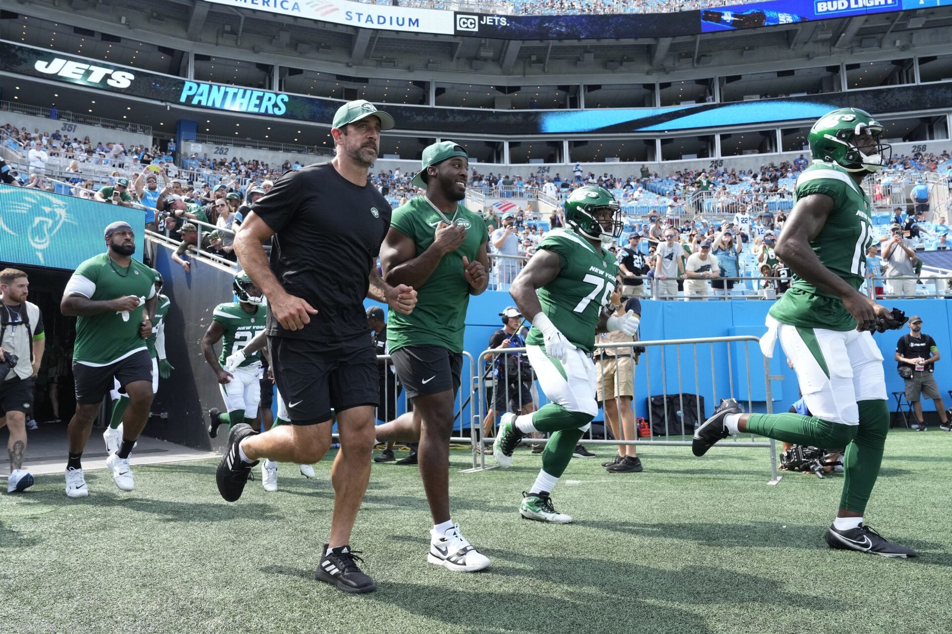 New York Jets quarterback Aaron Rodgers (8) runs on to the field in before the game at Bank of America Stadium.