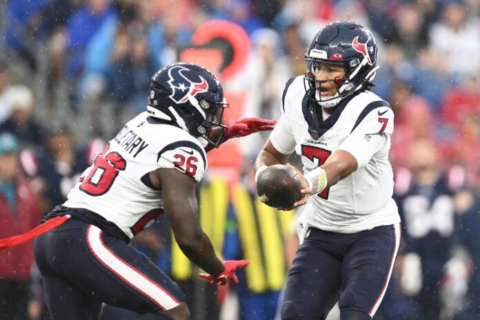 C.J. Stroud (7) hands the ball to running back Devin Singletary (26) during the first half of a game against the New England Patriots at Gillette Stadium.