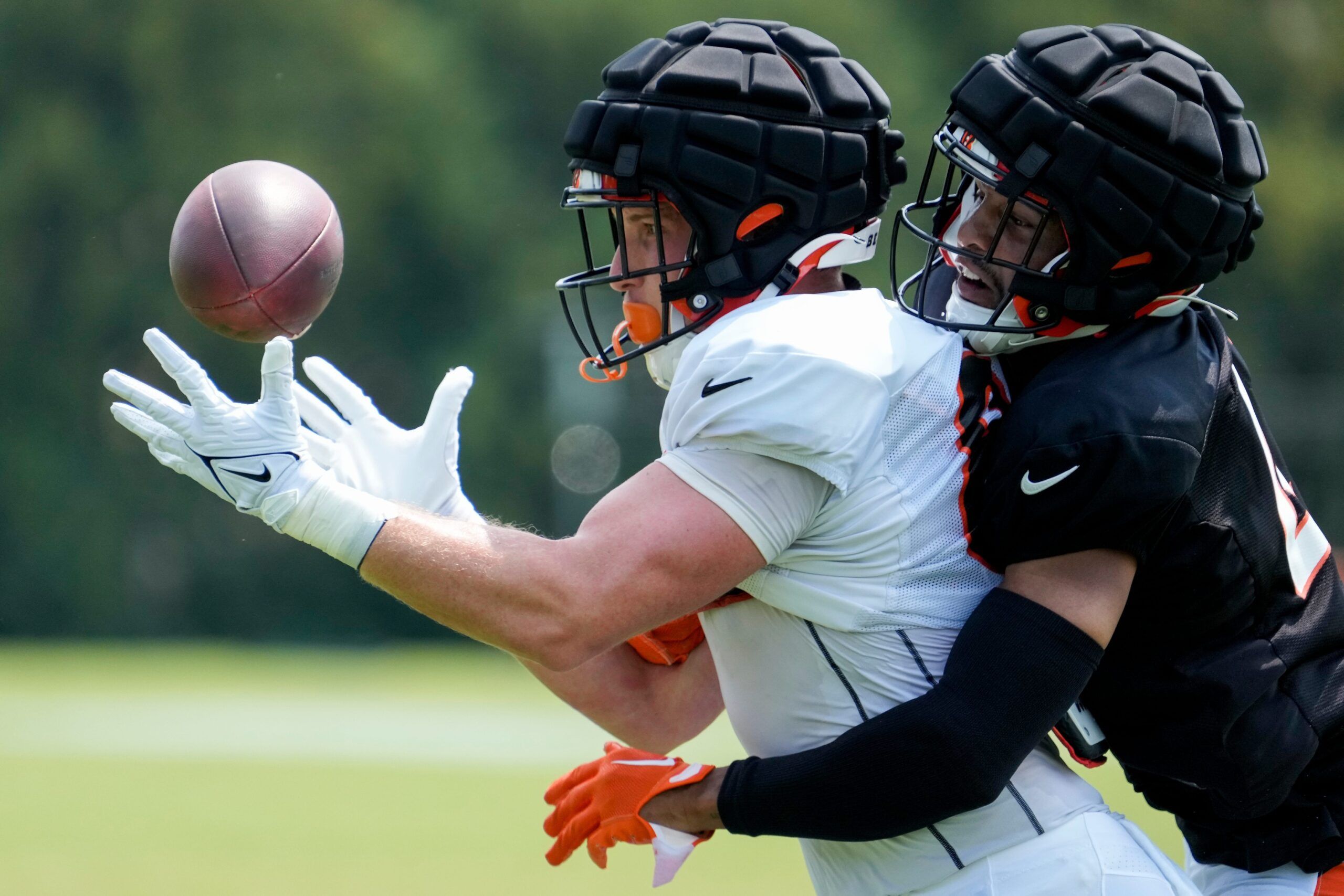 Drew Sample (89) and linebacker Keandre Jones (47) run a play during a training camp practice at the Paycor Stadium practice facility in downtown Cincinnati.