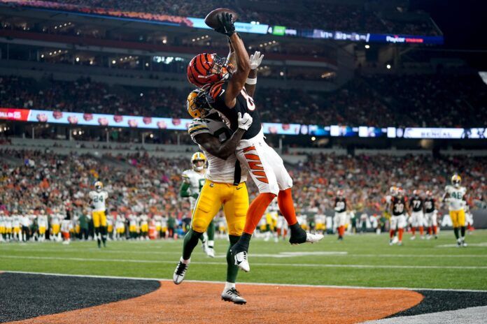 Andrei Iosivas (80) leaps to catch a pass in the end zone as Green Bay Packers cornerback William Hooper (27) defends in the third quarter at Paycor Stadium.