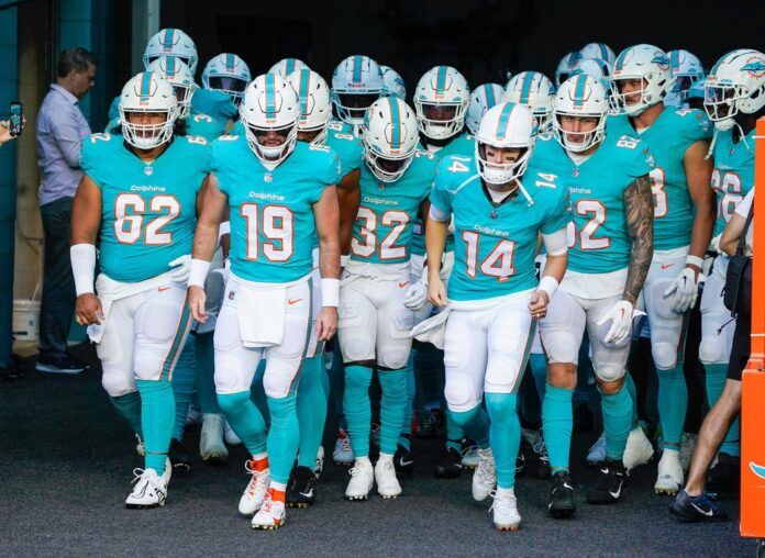 Skylar Thompson (19) and Mike White (14) lead the Miami Dolphins on the field before an NFL preseason game at Hard Rock Stadium on Friday.