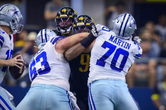 Tyler Biadasz (63) and guard Zack Martin (70) double team Washington Commanders defensive tackle Daron Payne (94) during the first quarter at AT&T Stadium.