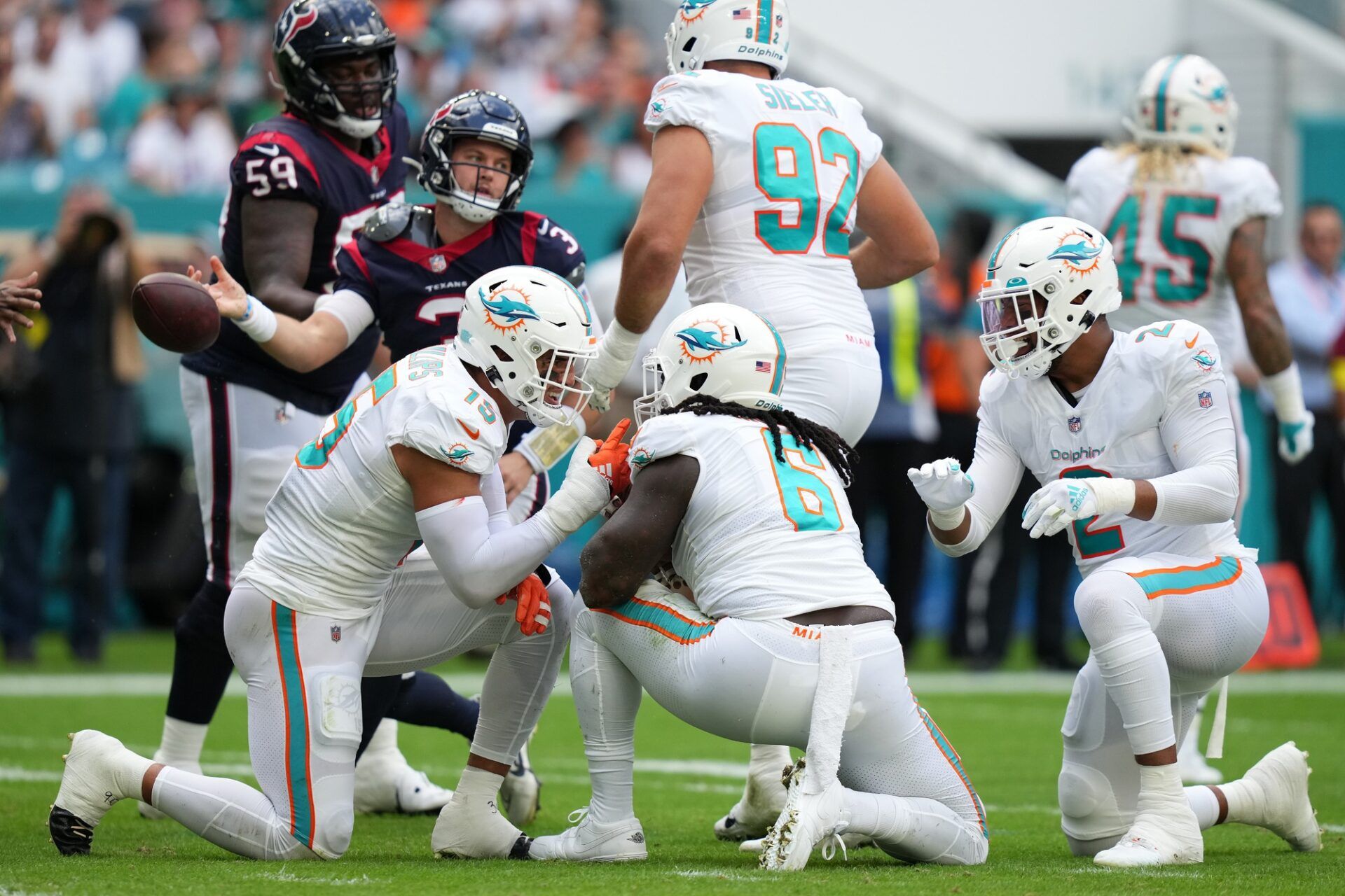 Melvin Ingram (6) celebrates his sack on Houston Texans quarterback Kyle Allen (3) with linebacker Jaelan Phillips (15) and linebacker Bradley Chubb (2) during the first half at Hard Rock Stadium.