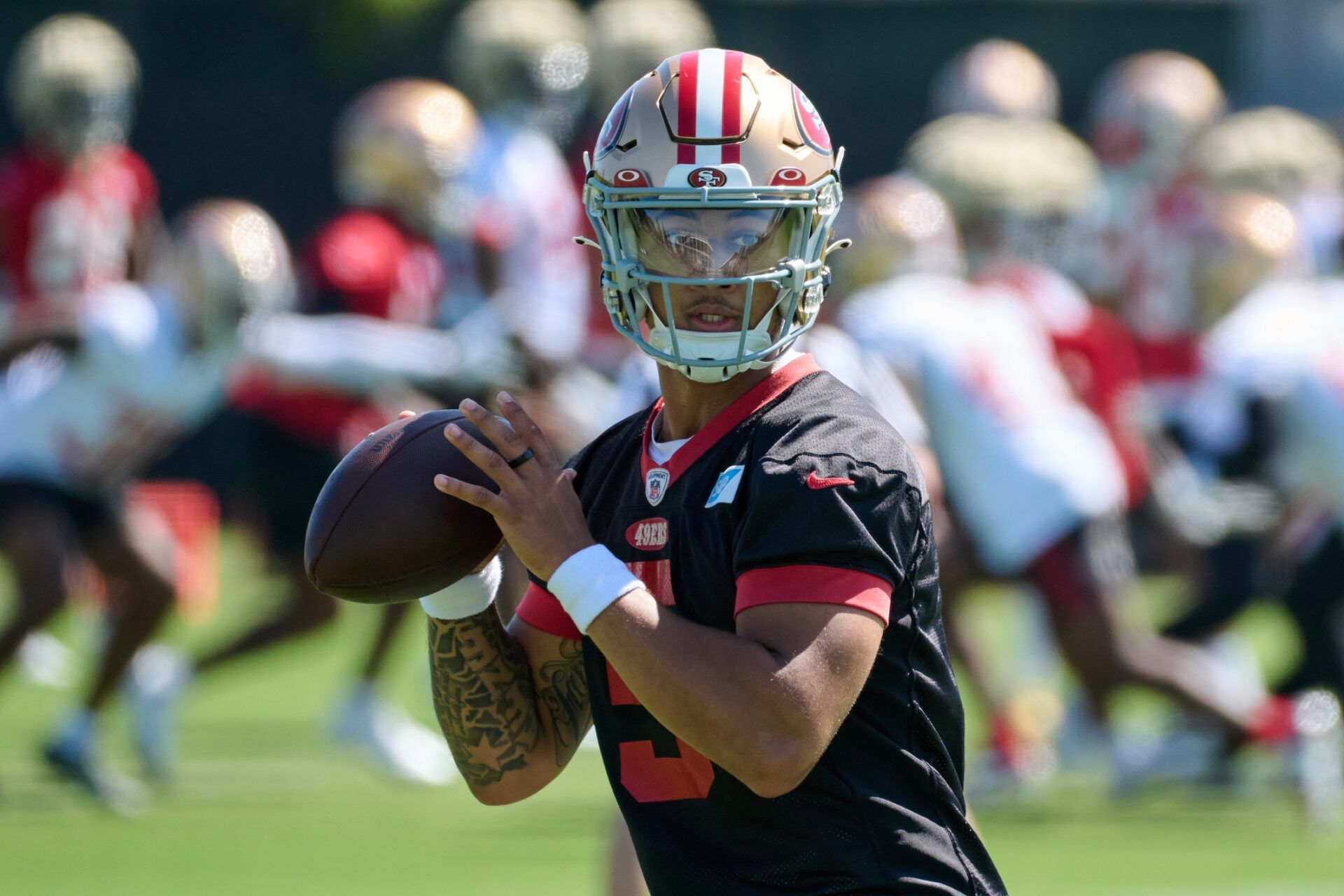 Trey Lance (5) looks before throwing a pass during training camp at the SAP Performance Facility.