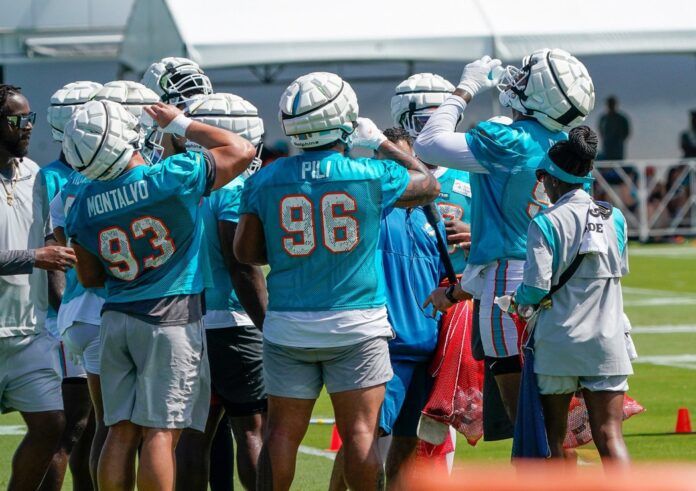 Miami Dolphins defensive line hydrates during a break at training camp at Baptist Health Training Complex.