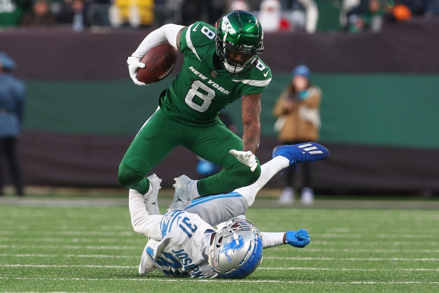 New York Jets WR Elijah Moore (8) runs over a Detroit Lions defender.