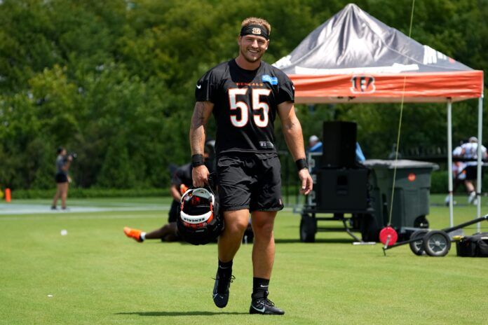 Cincinnati Bengals LB Logan Wilson (55) smiles as he walks with his helmet between drills at training camp.