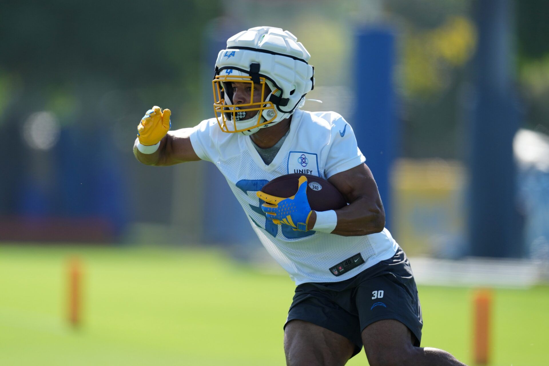 Austin Ekeler (30) wears a Guardian helmet cap during training camp at Jack Hammett Sports Complex.