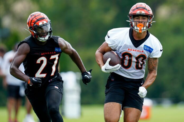 Cincinnati Bengals wide receiver Andrei Iosivas (80) runs from safety Jordan Battle (27) during training camp.