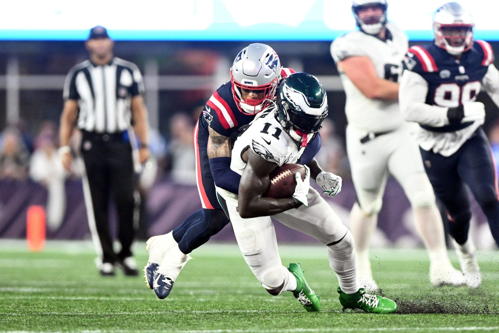 A.J. Brown (11) is tackled by New England Patriots cornerback Christian Gonzalez (6) during the second half at Gillette Stadium.