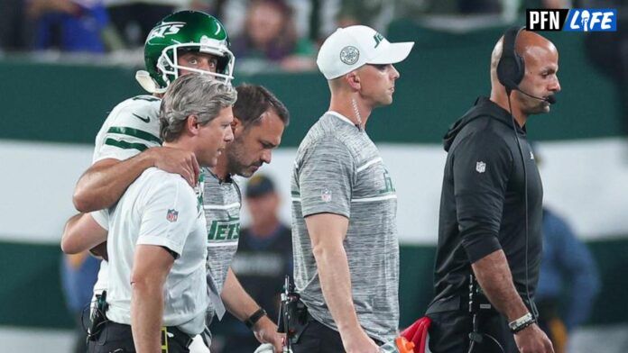 Medical staff help New York Jets quarterback Aaron Rodgers (8) off the field head behind coach Robert Saleh during the first half against the Buffalo Bills at MetLife Stadium.