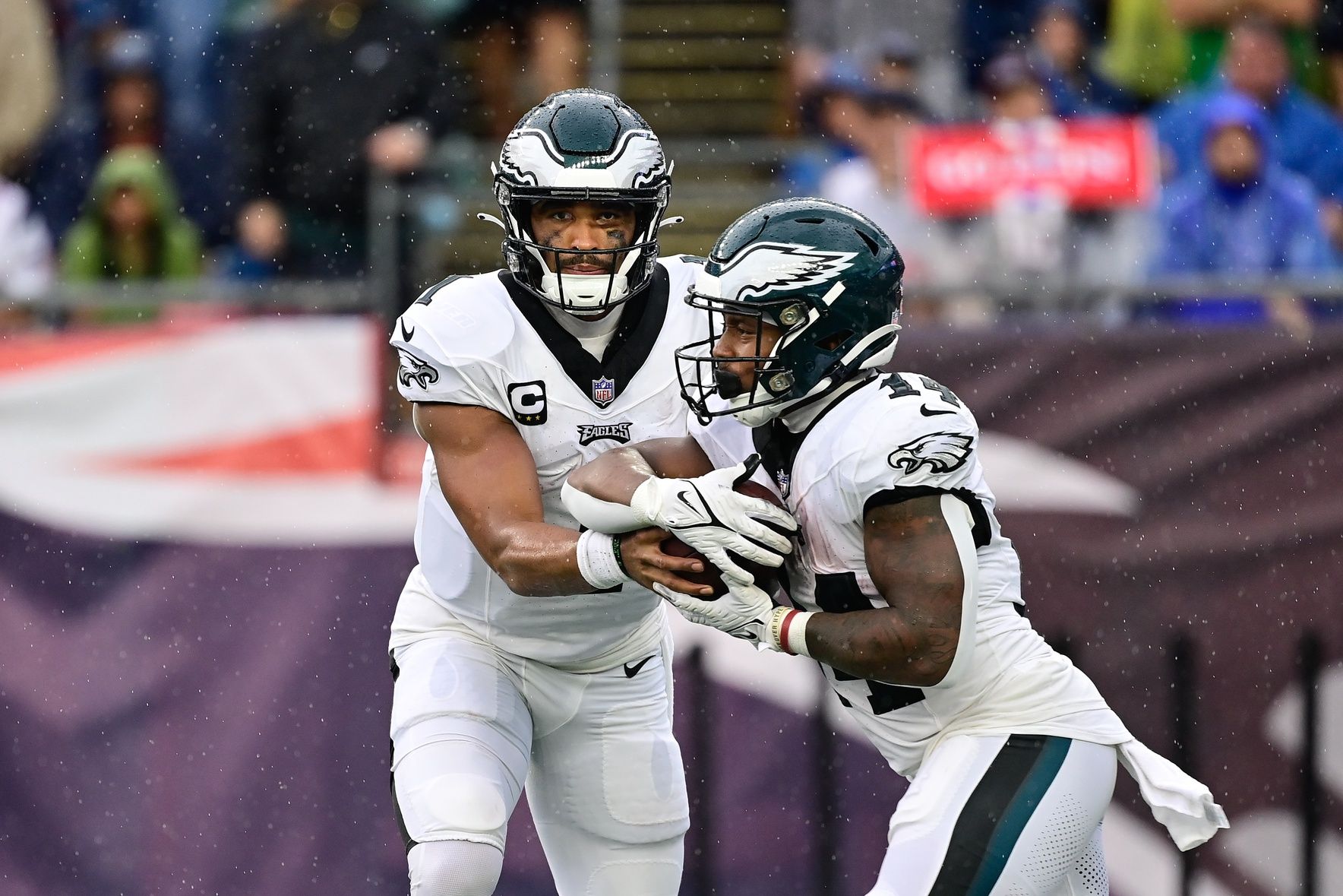 Jalen Hurts (1) hands the ball to running back Kenneth Gainwell (14) during the first half against the New England Patriots at Gillette Stadium.