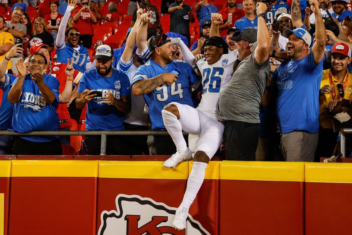 Jahmyr Gibbs (26) celebrates Lions' 21-20 win over Kansas City Chiefs with fans at Arrowhead Stadium.