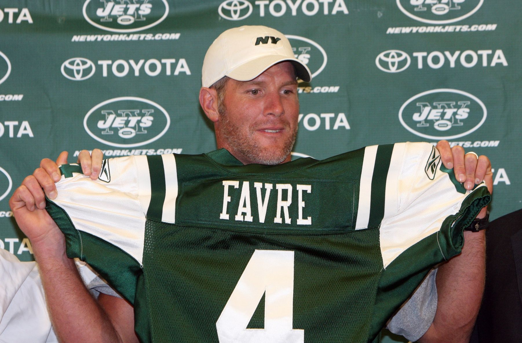 Brett Favre (4) holds up his new jersey before a preseason game against the Cleveland Browns at Cleveland Browns Stadium.