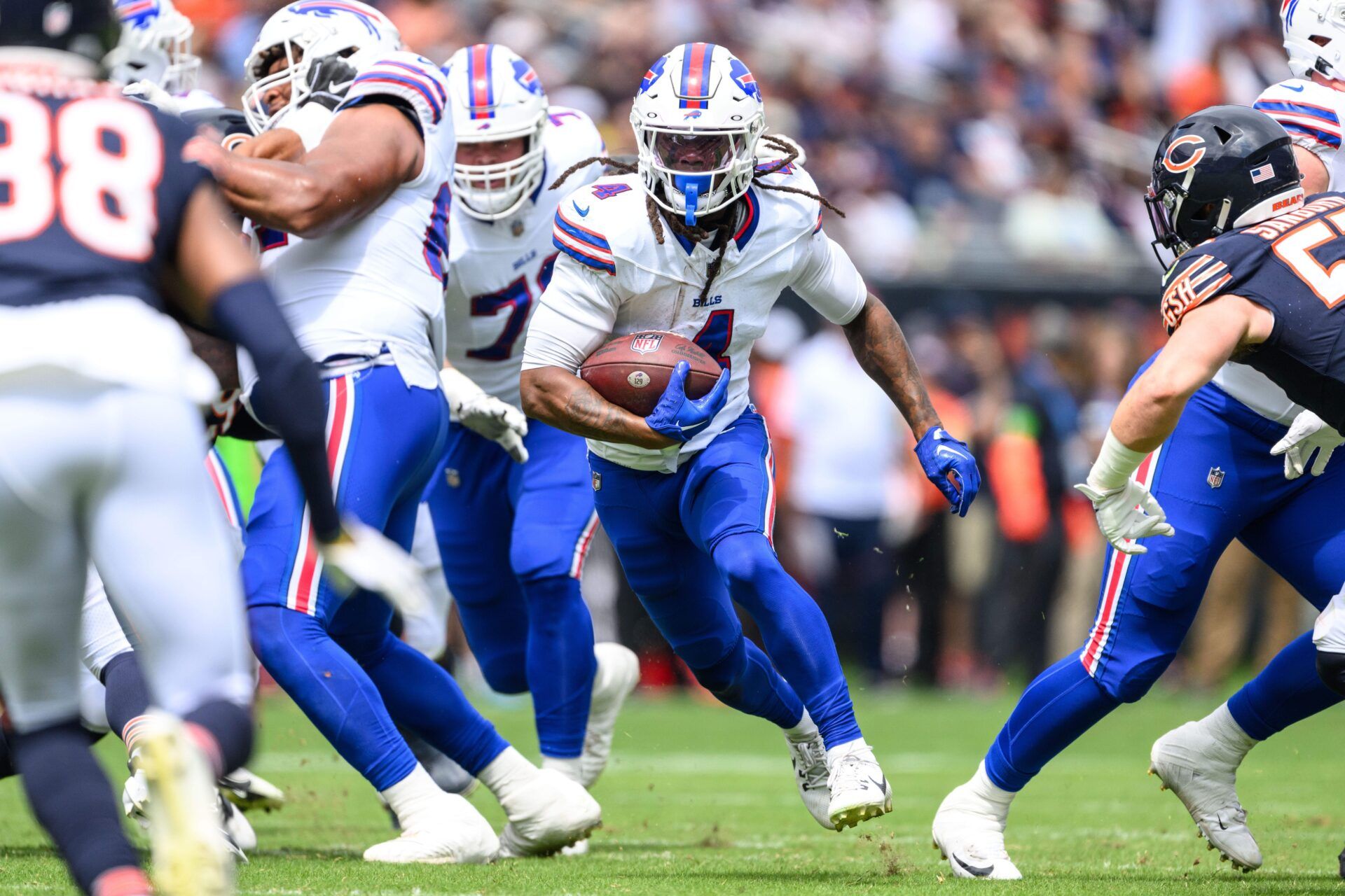 James Cook (4) runs the ball against the Chicago Bears during the first quarter at Soldier Field.