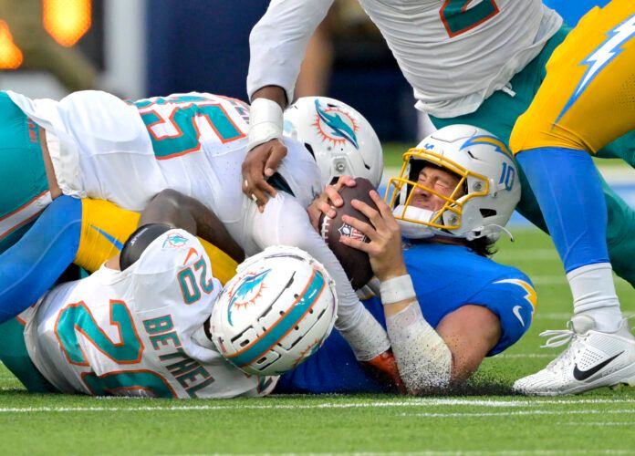 Sep 10, 2023; Inglewood, California, USA; Los Angeles Chargers quarterback Justin Herbert (10) is sacked by Miami Dolphins linebacker Jaelan Phillips (15) and cornerback Xavien Howard (25) in the final seconds of the game at SoFi Stadium. Mandatory Credit: Jayne Kamin-Oncea-USA TODAY Sports