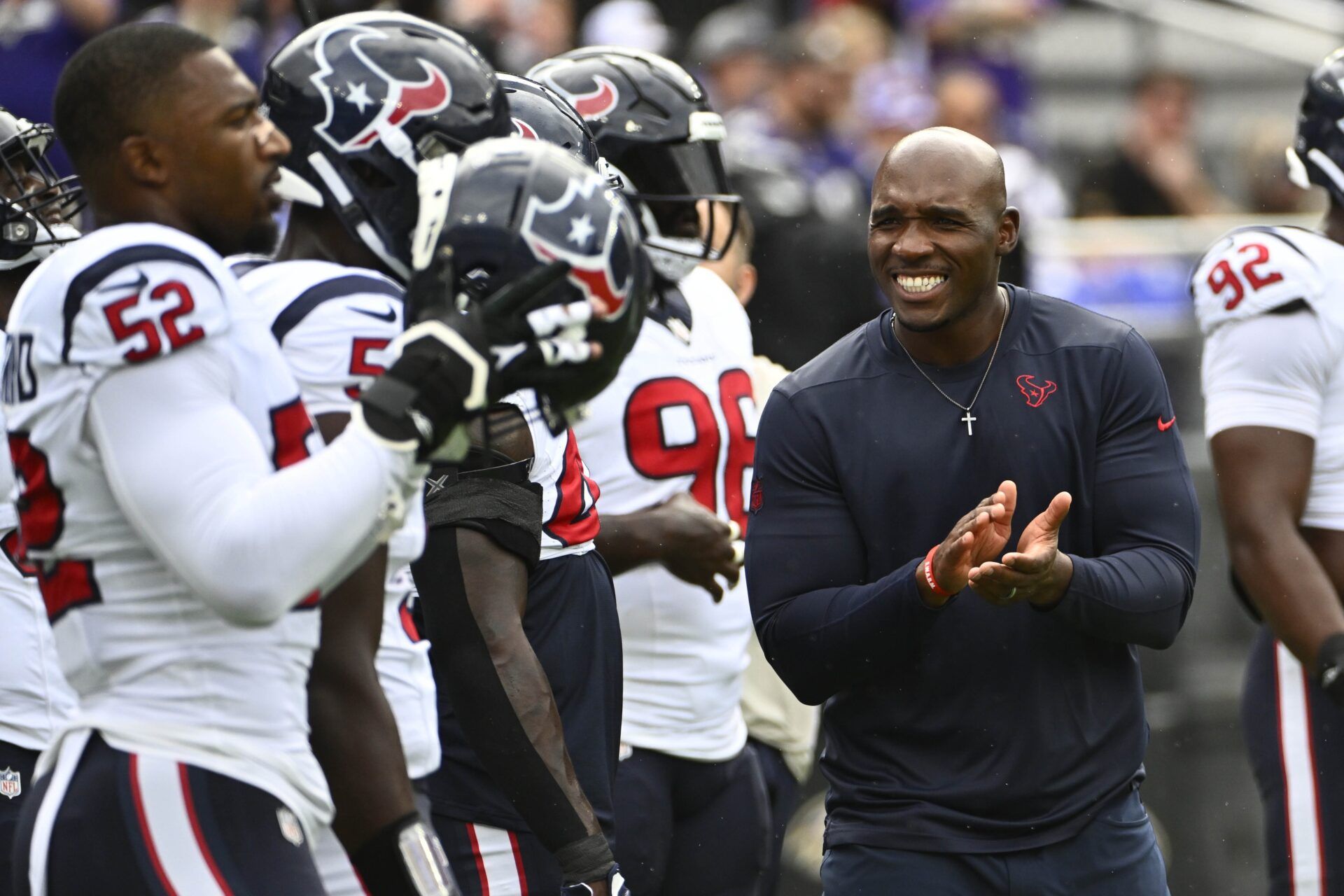 Houston Texans head coach DeMeco Ryans smiling on the field before a game.