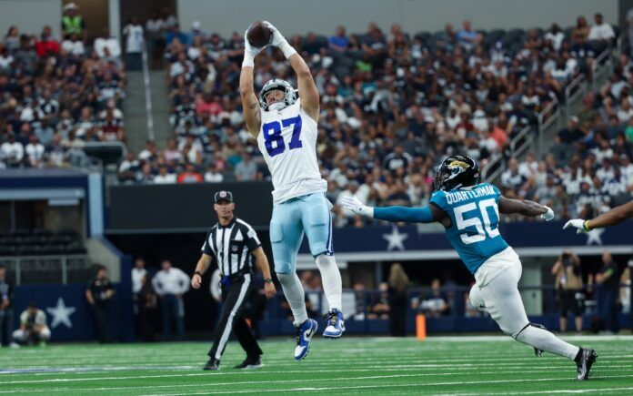 Dallas Cowboys tight end Jake Ferguson (87) makes a leaping catch past Jacksonville Jaguars linebacker Shaquille Quarterman (50) during the first quarter at AT&T Stadium.