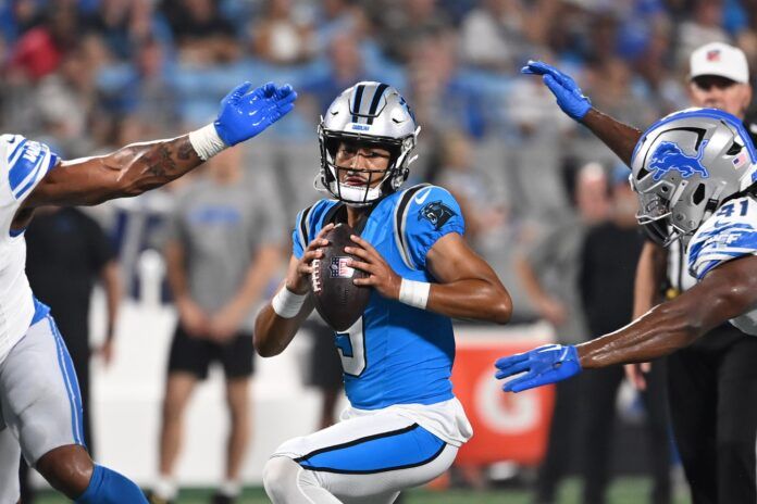 Bryce Young (9) is sacked by Detroit Lions linebacker James Houston (41) as defensive end Romeo Okwara (95) helps defend in the first quarter at Bank of America Stadium.