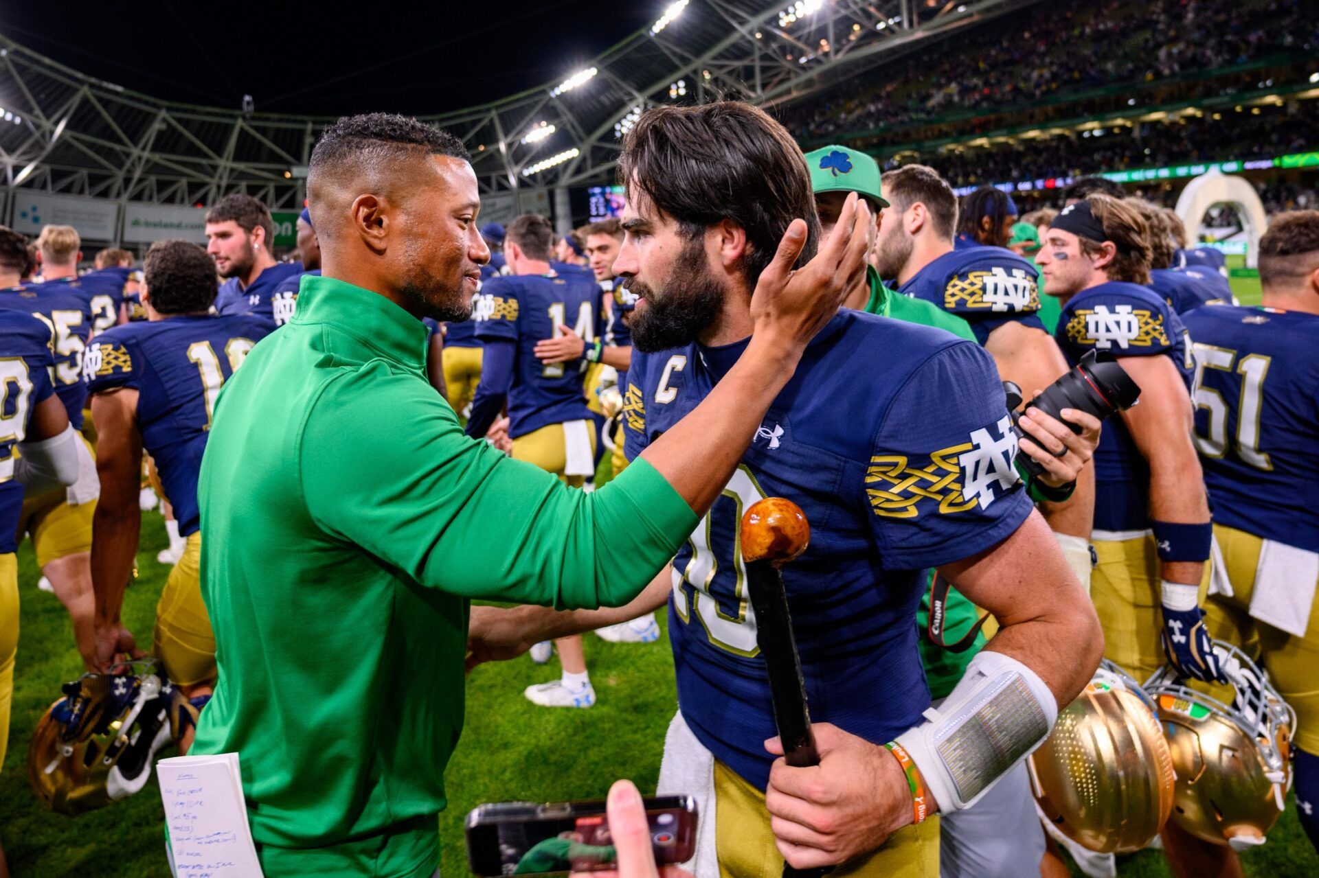 Marcus Freeman, left, celebrates with quarterback Sam Hartman (10) after Notre Dame defeated the Navy Midshipmen 42-3 at Aviva Stadium.