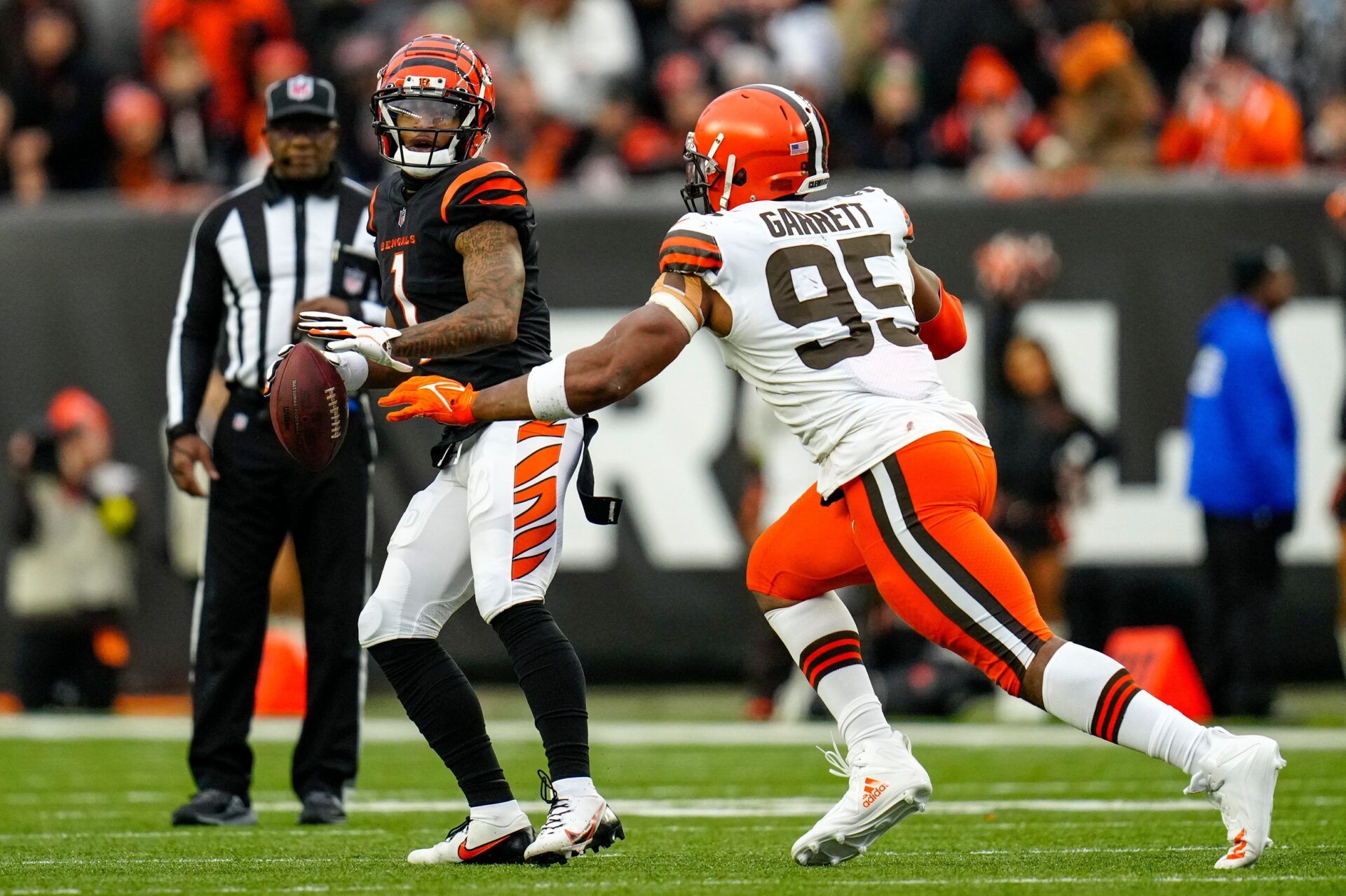 Cincinnati Bengals wide receiver Ja'Marr Chase (1) drops back to throw a pass on a trick play before being tackled by Cleveland Browns defensive end Myles Garrett (95) in the fourth quarter of the NFL Week 14 game between the Cincinnati Bengals and the Cleveland Browns at Paycor Stadium in Cincinnati on Sunday, Dec. 11, 2022. The Bengals improved to 9-4 with a 23-10 win over the Browns.