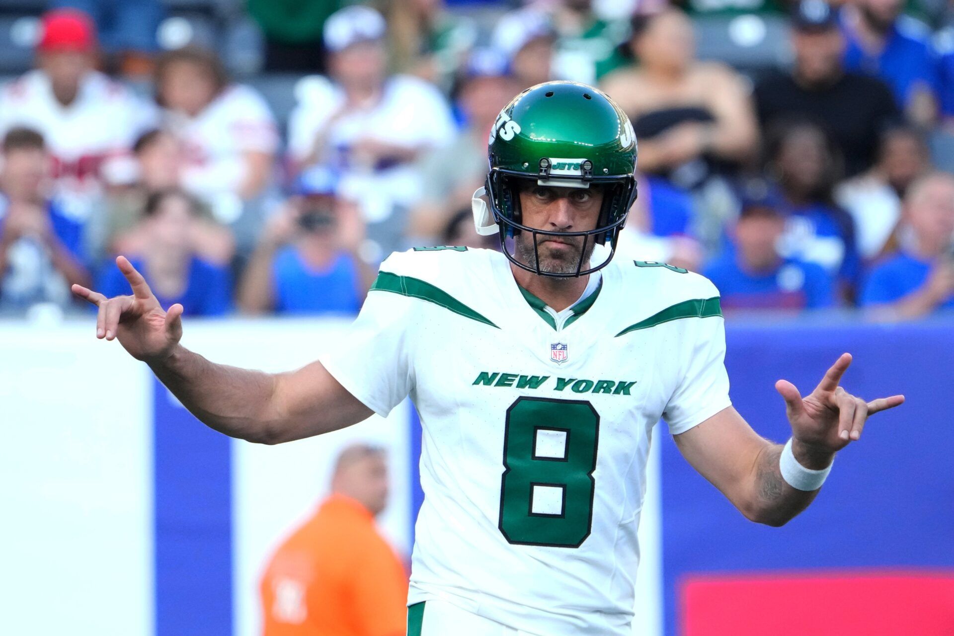 Aaron Rodgers (8) greets the cheers of fans on his first appearance as a Jet against the Giants at MetLife Stadium.