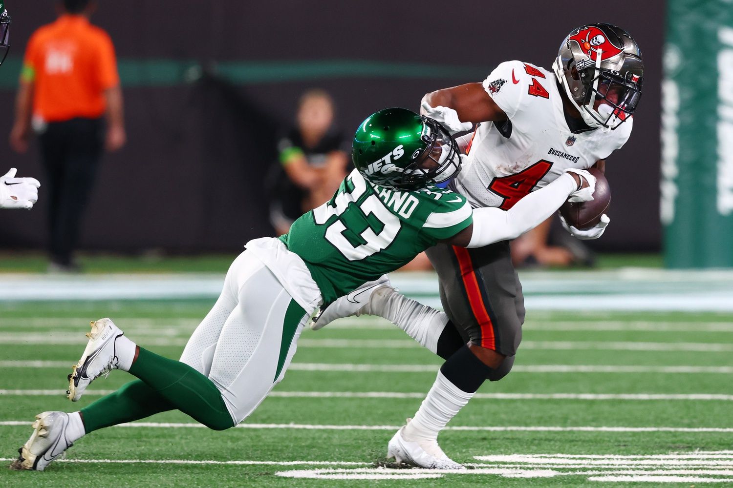 Sean Tucker (44) runs with the ball while New York Jets cornerback Jimmy Moreland (33) attempts to tackle him during the first half at MetLife Stadium.