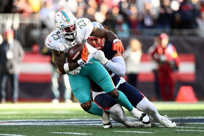 Miami Dolphins RB Jeff Wilson Jr. (23) is tackled by New England Patriots LB Jahlani Tavai (48).