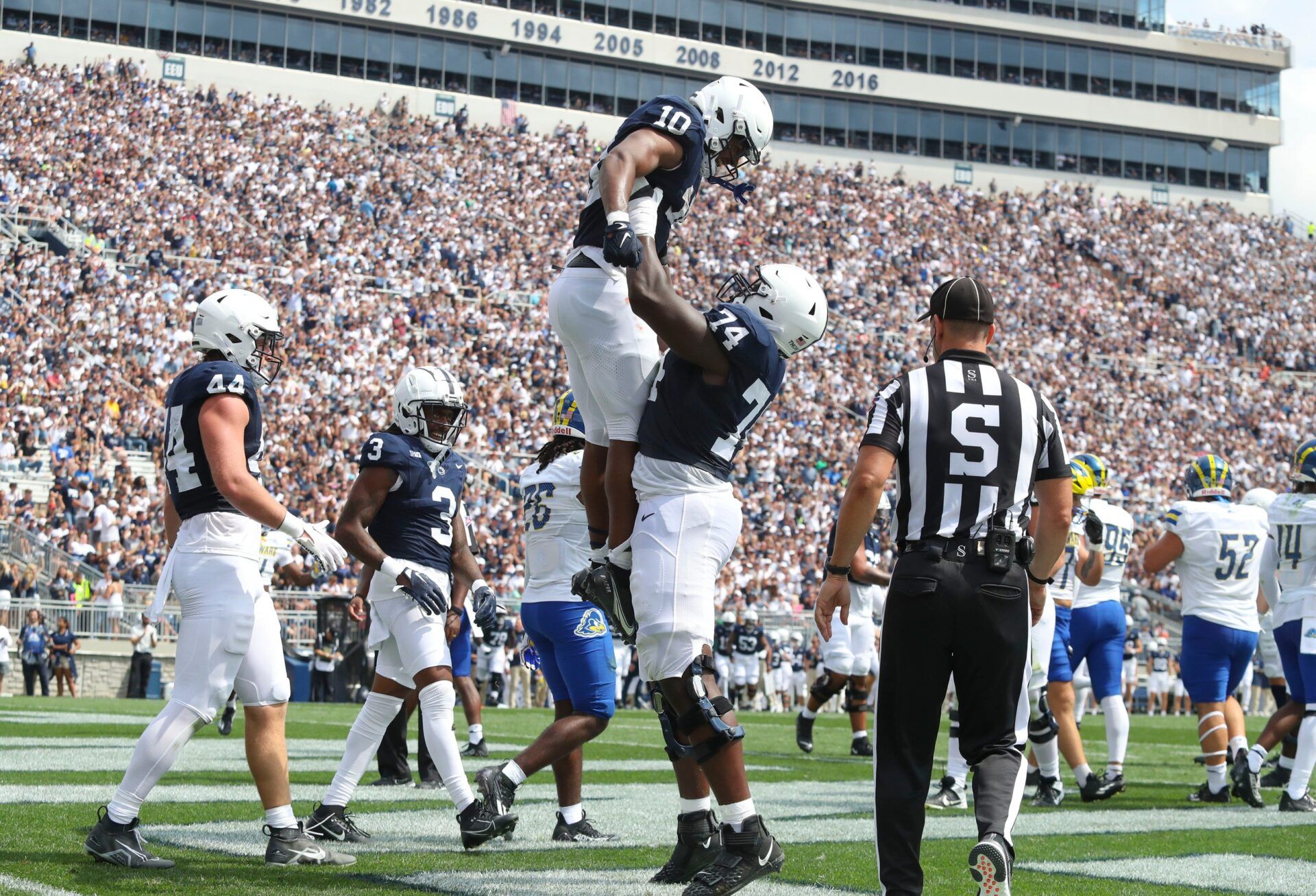 Penn State running back Nicholas Singleton is hoisted by lineman Olumuyiwa Fashanu after Singleton scored in the second quarter against Delaware at Beaver Stadium.