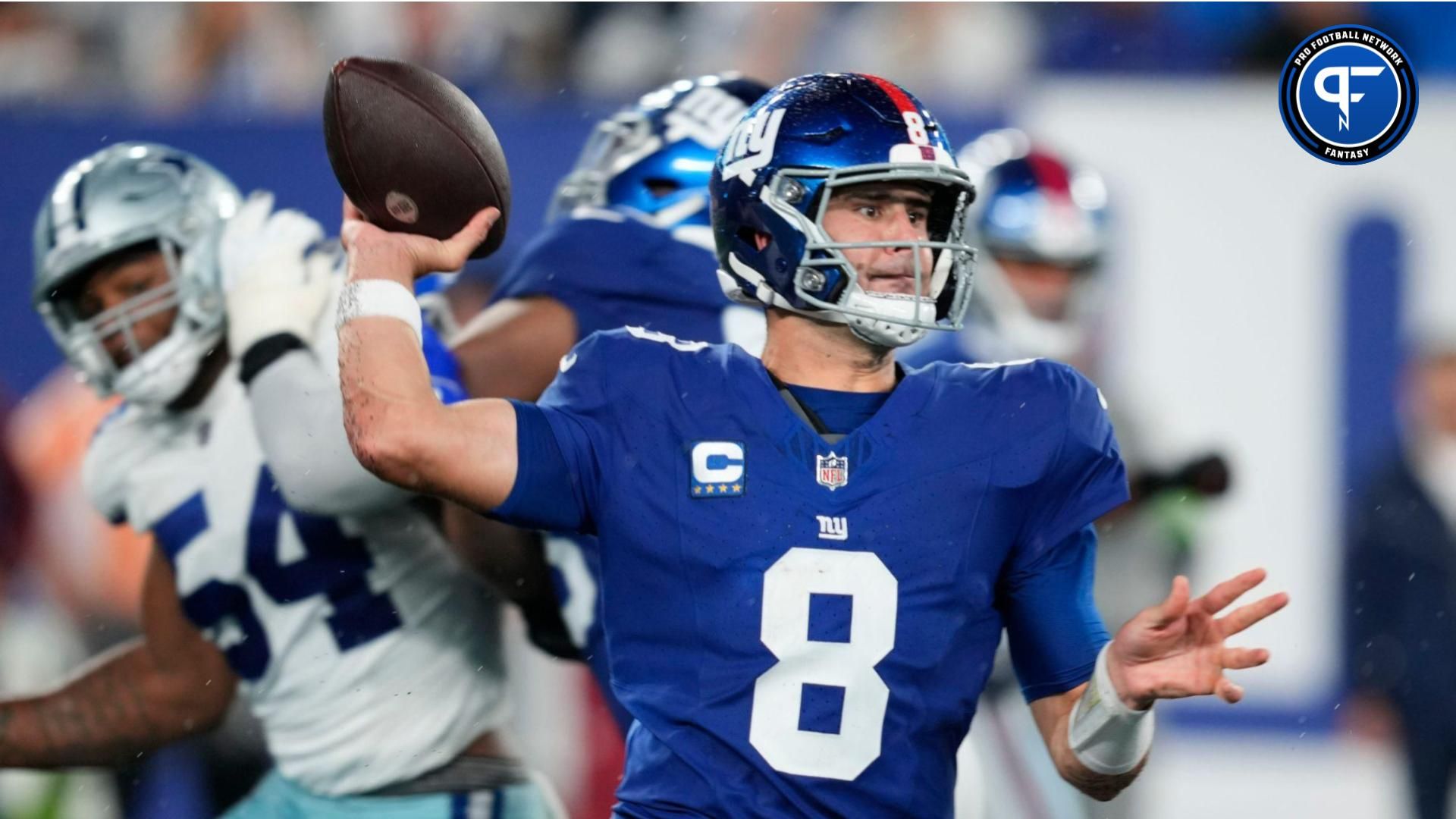 New York Giants quarterback Daniel Jones (8) throws a pass as he receives help from his offensive line.