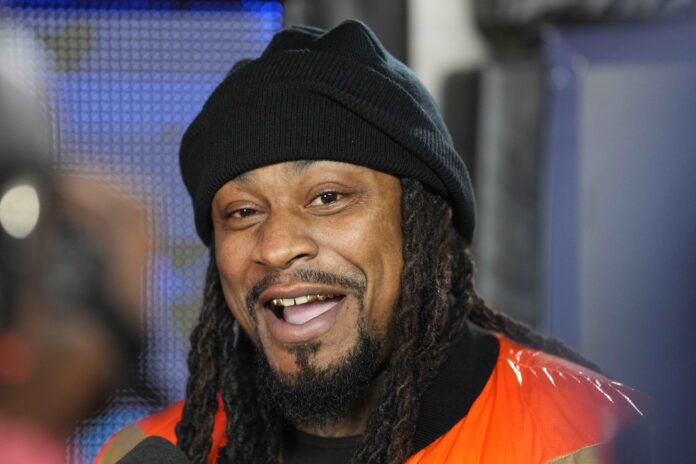 California Golden Bears former running back Marshawn Lynch is interviewed on the sideline during the second quarter of the game between the California Golden Bears and the Washington Huskies at FTX Field at California Memorial Stadium.